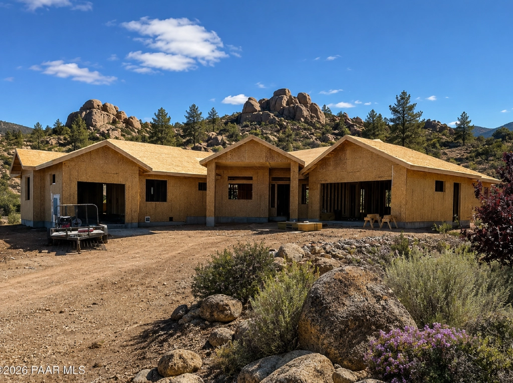 Wood-framed home under construction in rocky landscape