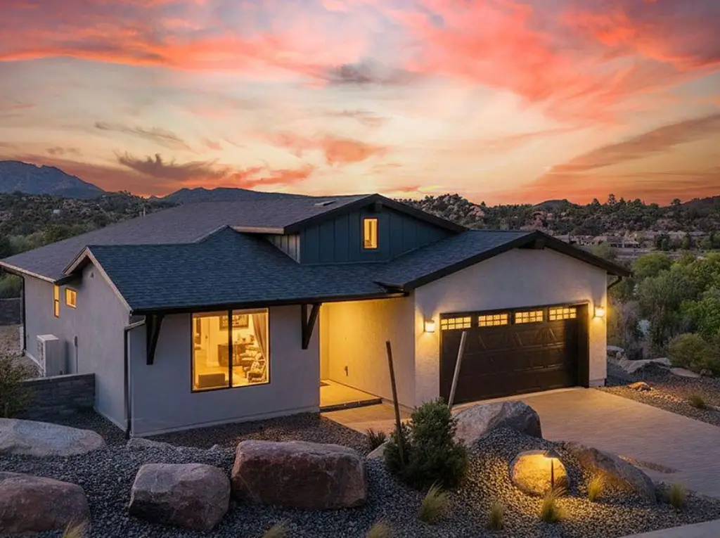 Modern desert home at sunset with lit garage